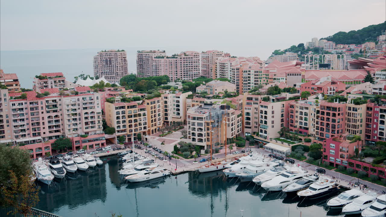 View of boats docked in the Monaco Marina with the skyline of the city on the background