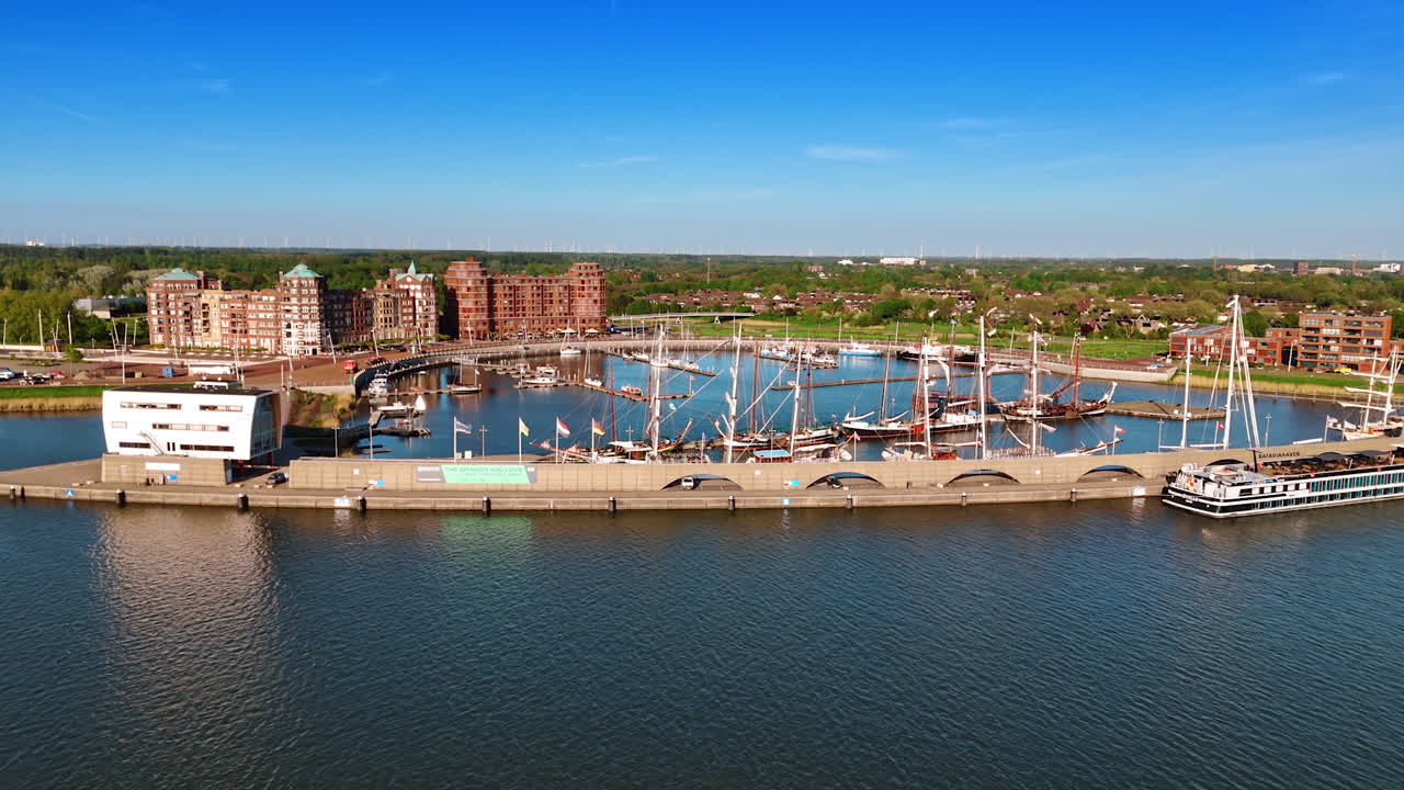 Approaching the berth with old-fashioned ships on the anchor. Museum Batavialand in Lelystad, the Netherlands. Aerial view.