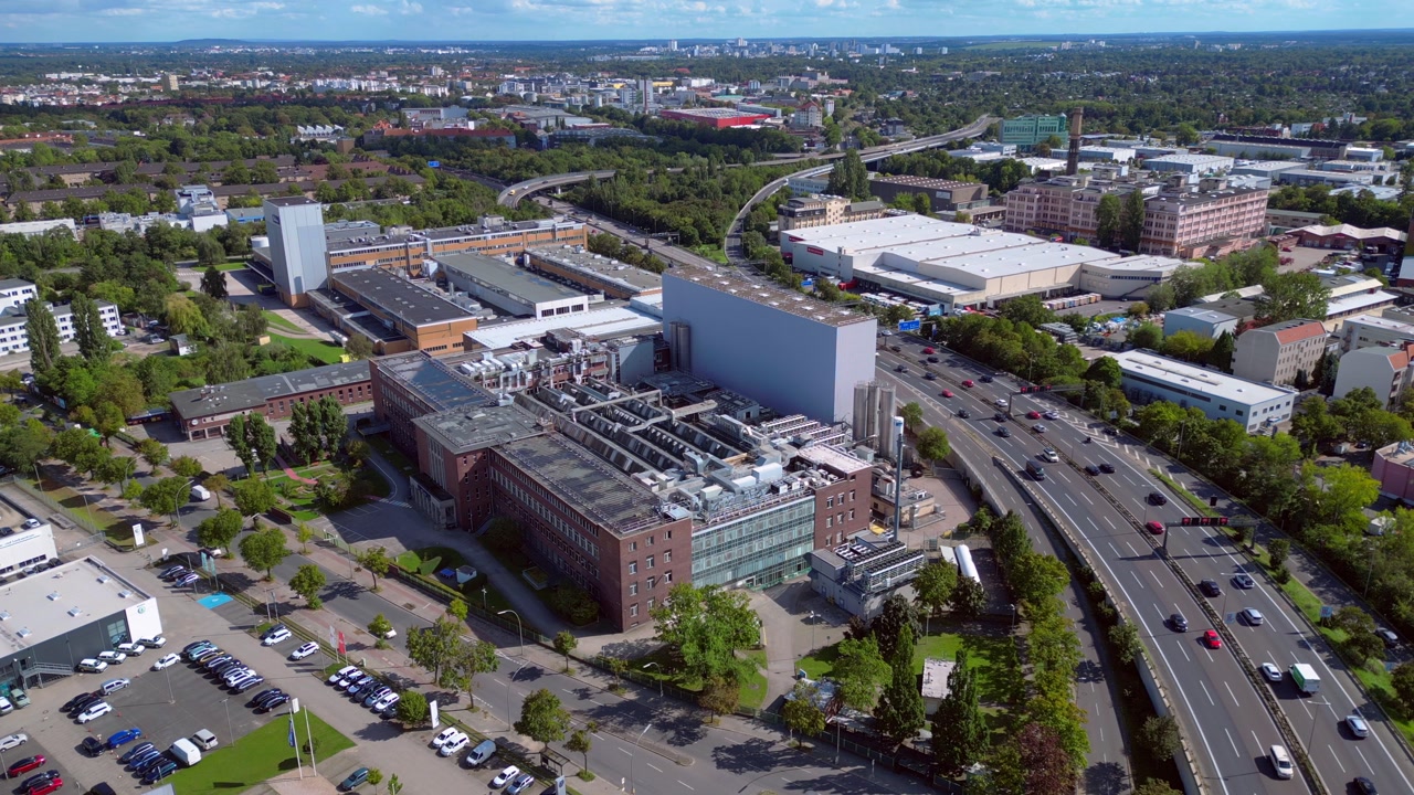 highway crossing an industrial area in Berlin, with traffic flowing on a sunny day. Lovely aerial view flight drone shot from above
