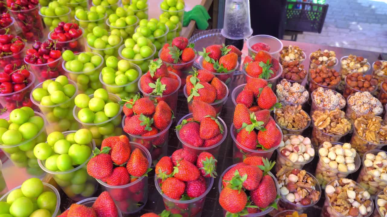 Mercato in Georgia, in bicchieri di plastica ci sono frutta secca e noci.