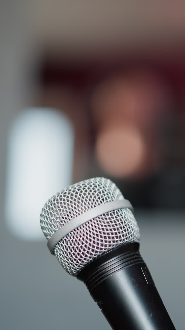 toma de primer plano de un micrófono con un fondo borroso, enfatizando los detalles del micrófón mientras crea un fondo suave y fuera de enfoque. el fondo borroso sugiere un entorno de estudio