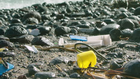 Stunning-low-level-shot-of-waves-breaking-towards-waste-plastic-on-the-beach