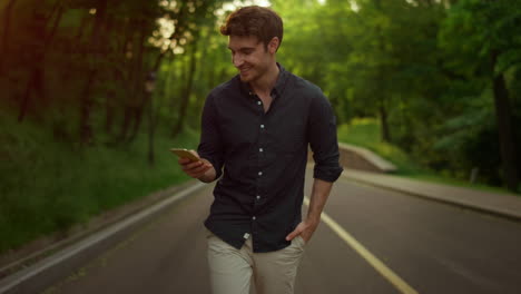 Focused-man-texting-message-outdoors.-Handsome-guy-using-smartphone-in-park