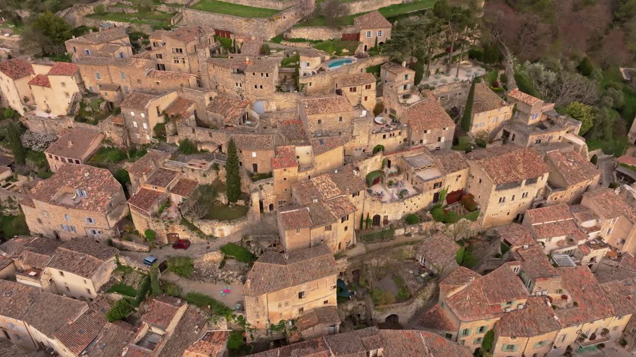 Vista aerea del sole che sorge sulla vecchia Lacoste e sulla fortezza in cima alla collina in Francia