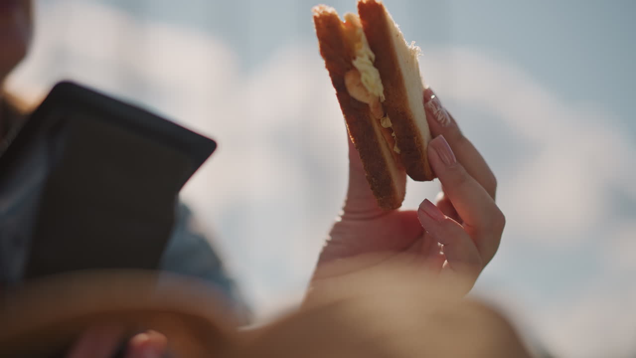 White woman holding layered sandwich closeup, golden crust and butter sheen, fingers with pink nails, sunlit outdoor vibe, focus on filling and texture for social media tasting clip