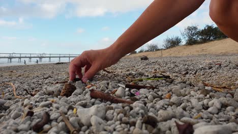 Eine-Person,-Die-Plastik-Aufsammelt,-Das-An-Einem-Beliebten-Strand-In-Der-Nähe-Einer-Stadt-Gewaschen-Wurde