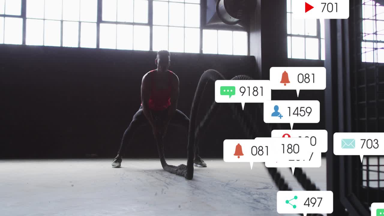 Man gripping ropes, creating waves and slams for fitness while social alerts covering lower frame