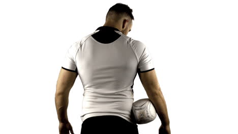 serious rugby player holds rugby ball