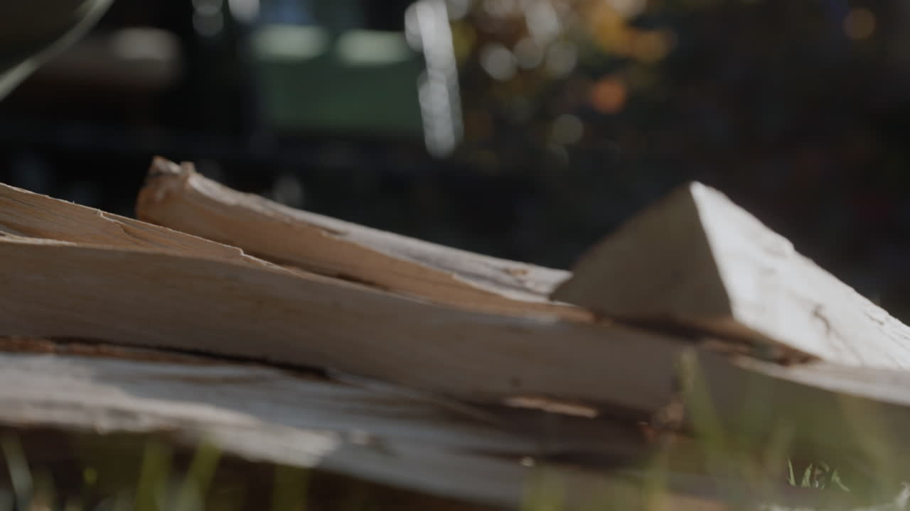 A man picks up wooden logs