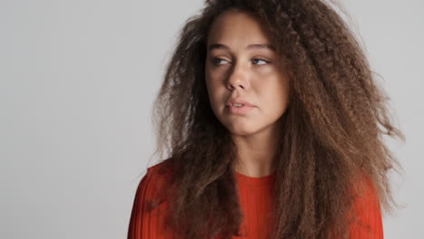 scared caucasian curly haired woman looking around.