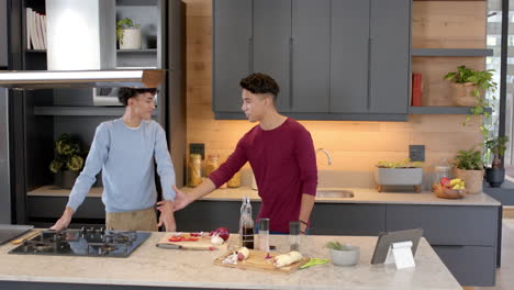 preparing meal, multiracial gay couple chopping vegetables and shaking hands in kitchen, at home