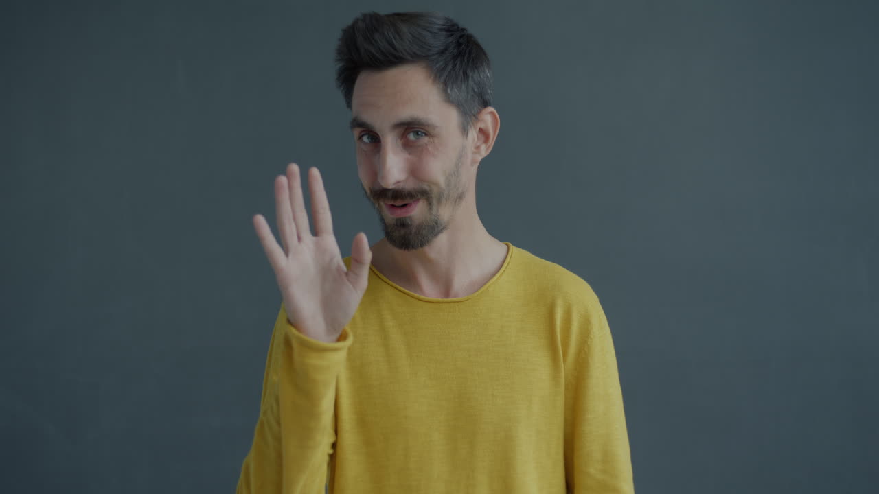 Man in a yellow shirt greeting