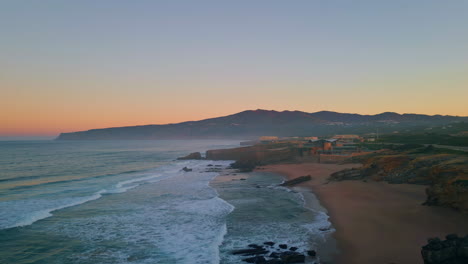 maravilloso paisaje marítimo de la noche costa lavada por las olas del océano. vista aérea en el cielo rosado.