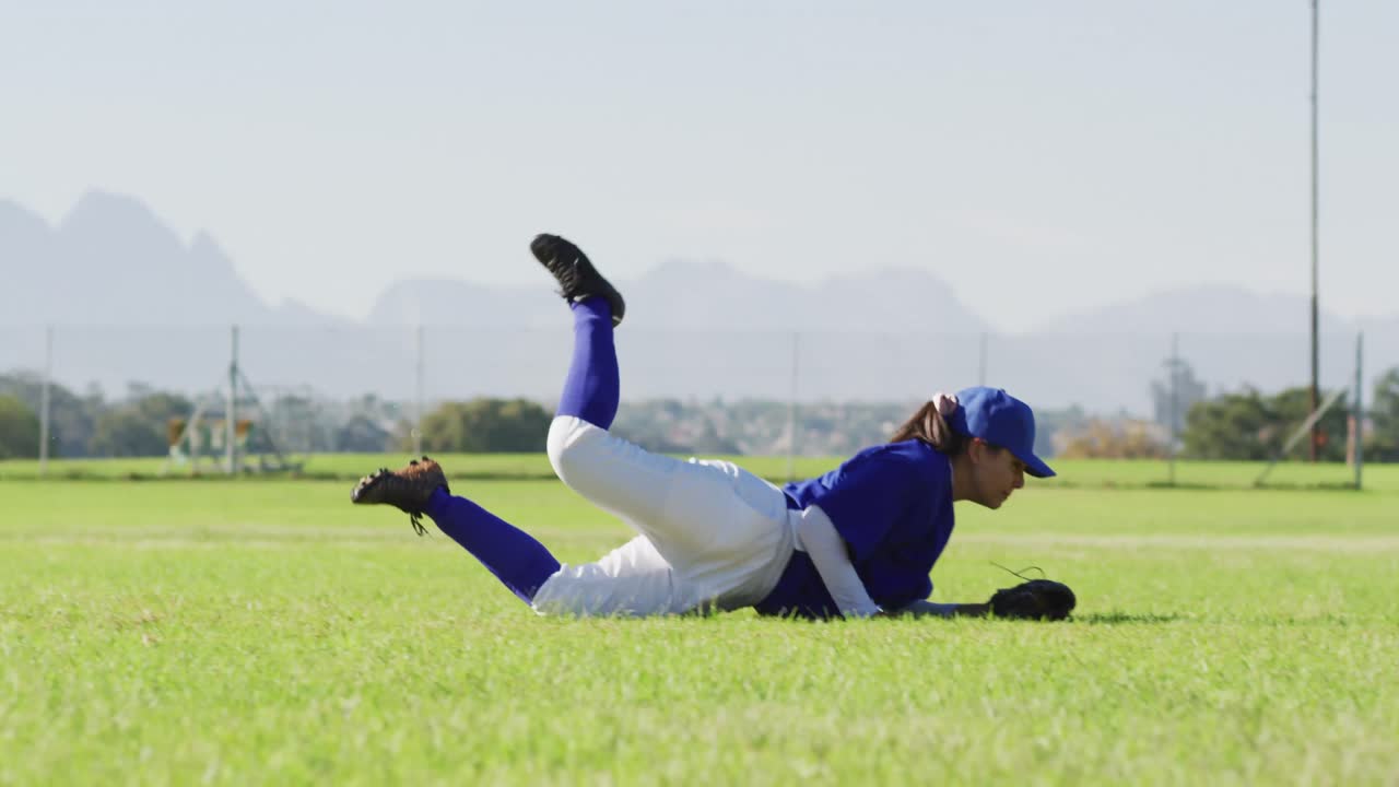백인 여성 야구 선수, 야구장에서 공을 잡고 다이빙하는 필더