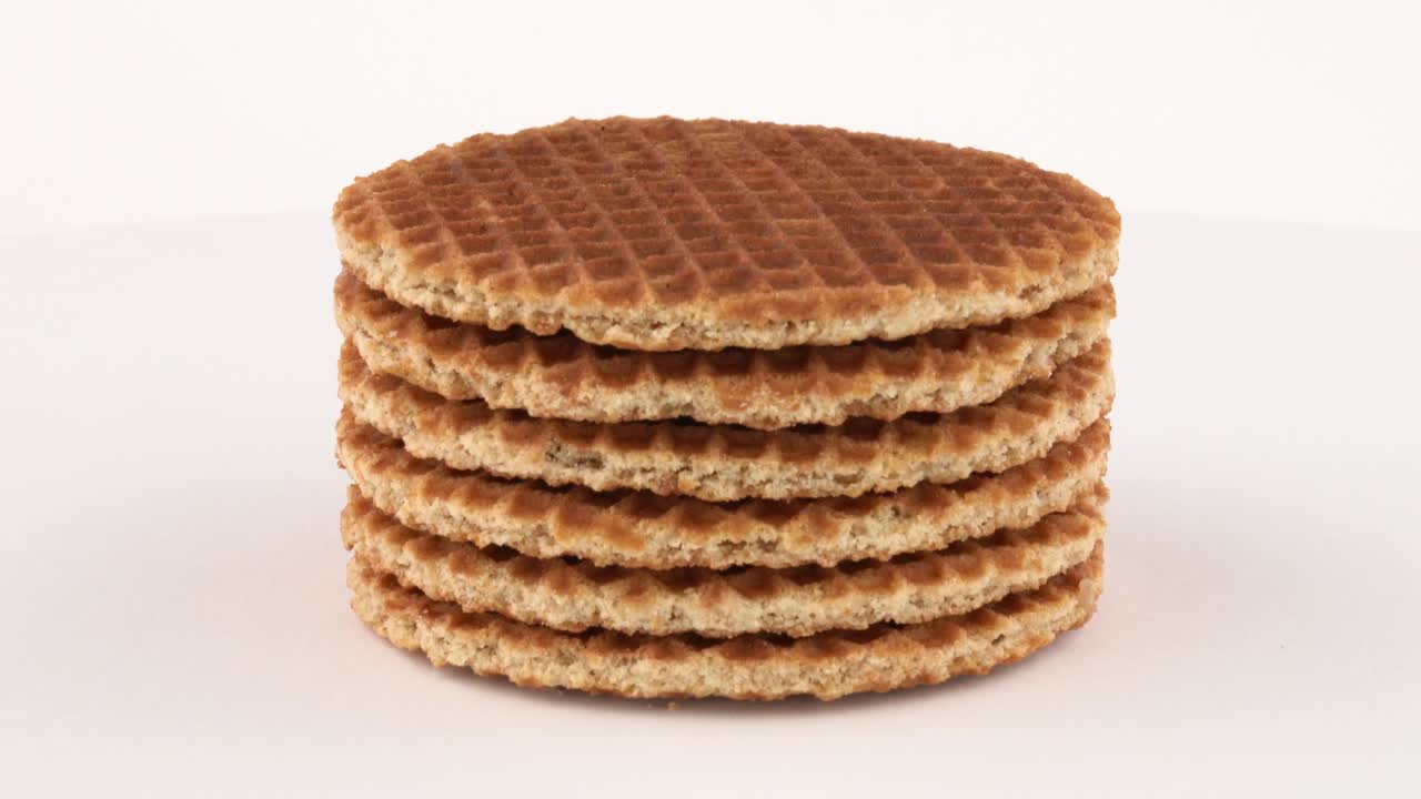 스트로프와펠 (dutch waffles) 쿠키는 회전 테이블에서 회전합니다. 색 배경에 고립되어 있습니다.