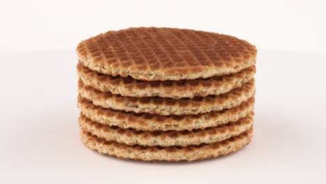 stroopwafel (waffles holandeses) galletas que giran en la mesa giratoria. aisladas sobre un fondo blanco.