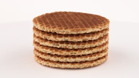 stroopwafel (dutch wafels) cookies rotating on turn table. isolated on white background.