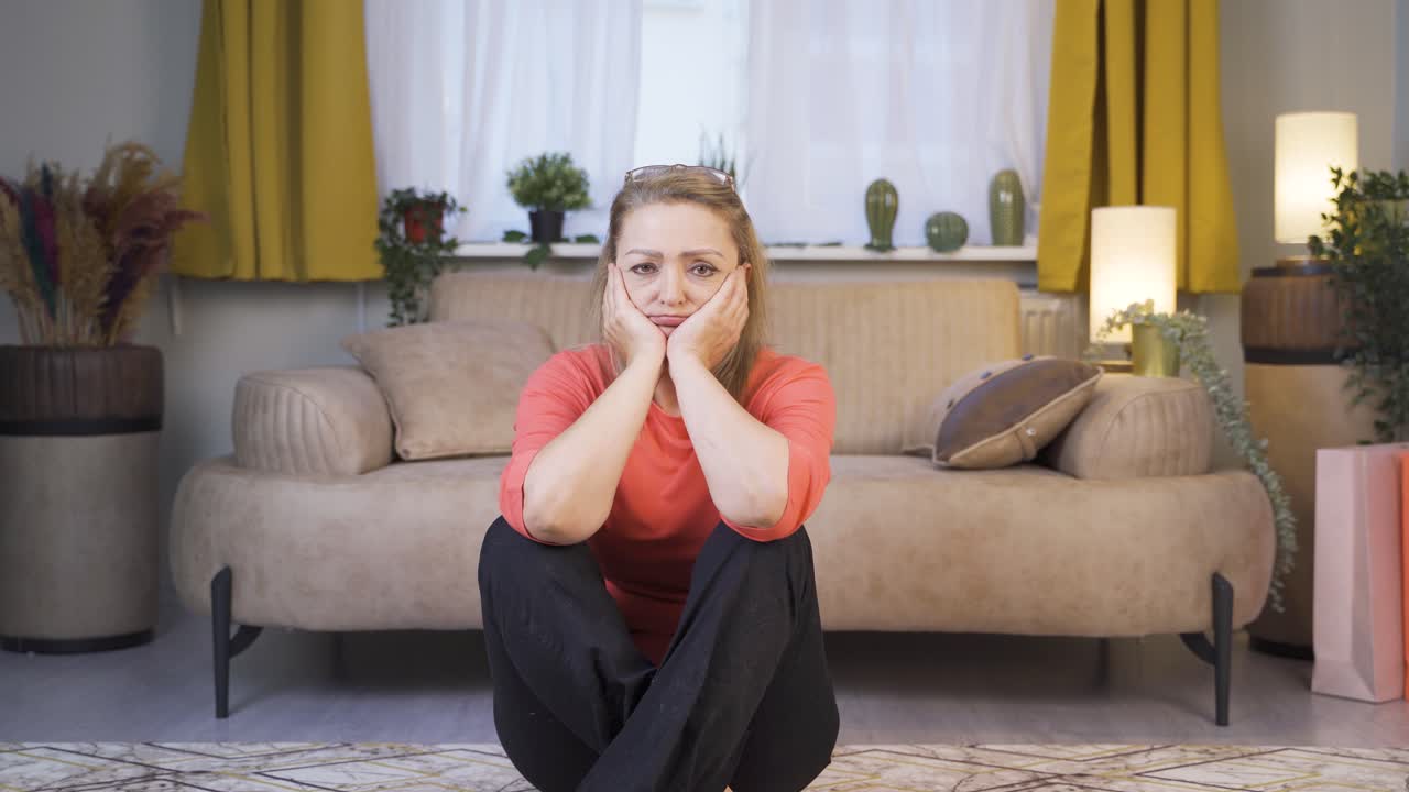 женщина выглядит подавленной в камеру.