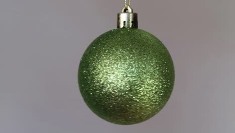 a pretty sparkly green christmas bauble or ball with movement