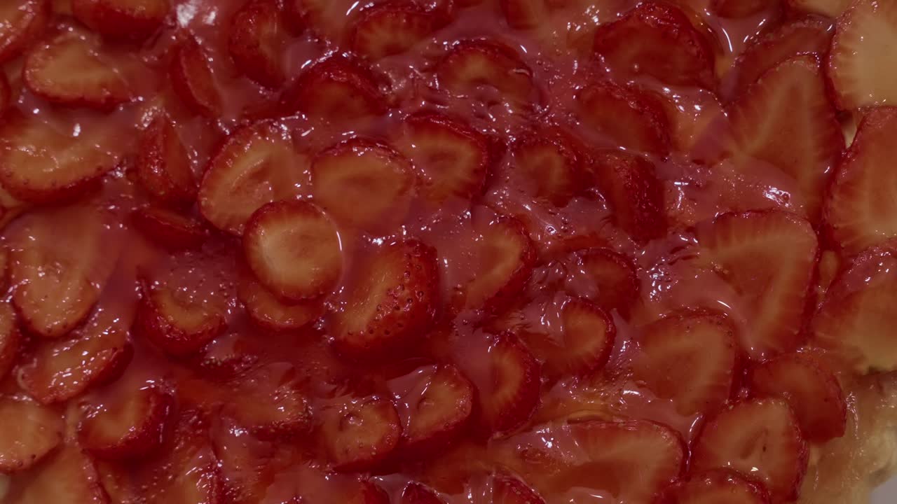 달콤하고 윤기 있는 질감을 내는 선명한 빨간색 조각이 있는 글레이즈 딸기 타르트의 클로즈업 사진