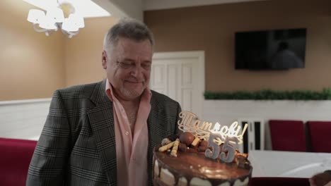 happy respectable old man holding cake. celebrating birthday anniversary