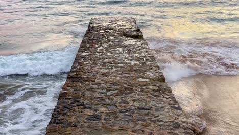 wharf on the waves of a small storm track covered with water on the sea