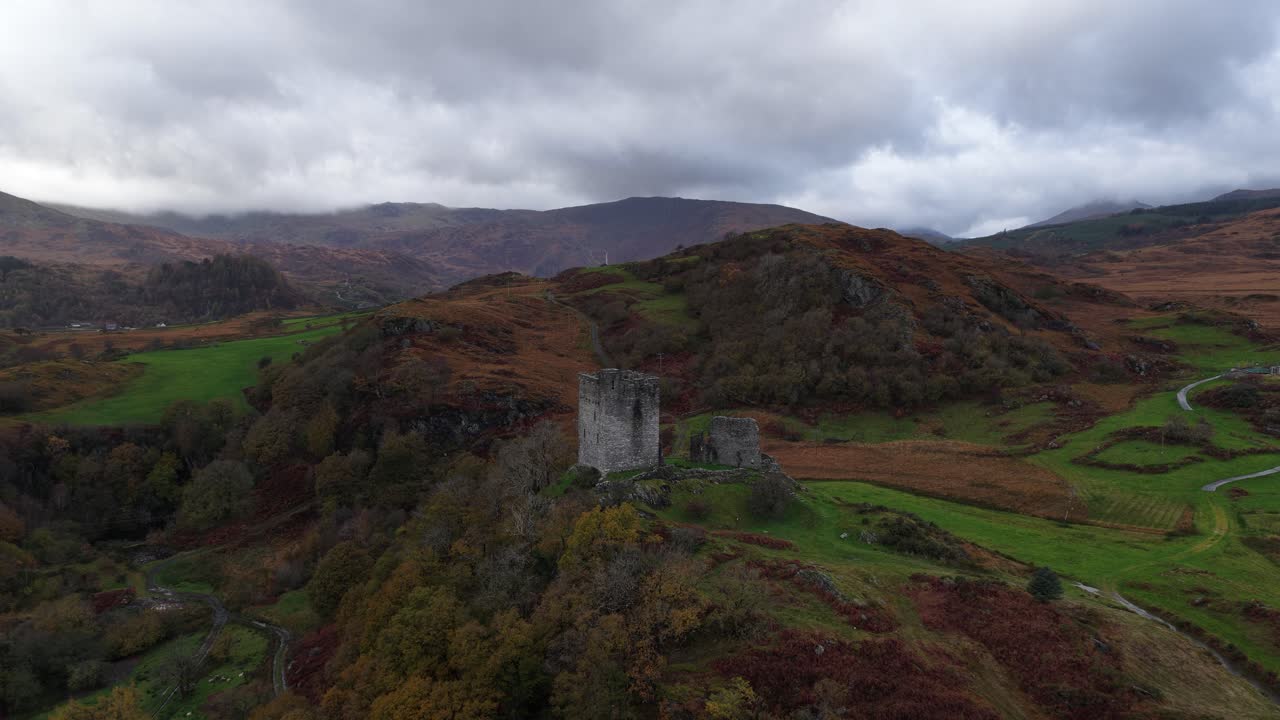 Aerial drone video of Dolwyddelan Castle in Snowdonia National Park, showing the medieval hilltop ruins and the dramatic Welsh highland landscape surrounding this historic stronghold