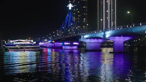 cinematic night view of tran thi ly bridge over han river and cruise sailing in da nang city of vietnam illuminated with lights