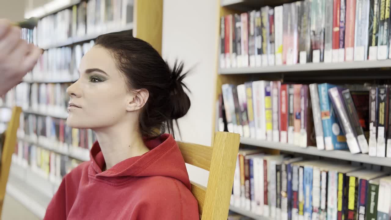 mujeres de cabello oscuro maquillándose, sonriendo al maquillador