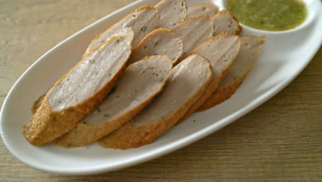 fried chinese fish cake or fish ball line sliced with spicy seafood dipping sauce