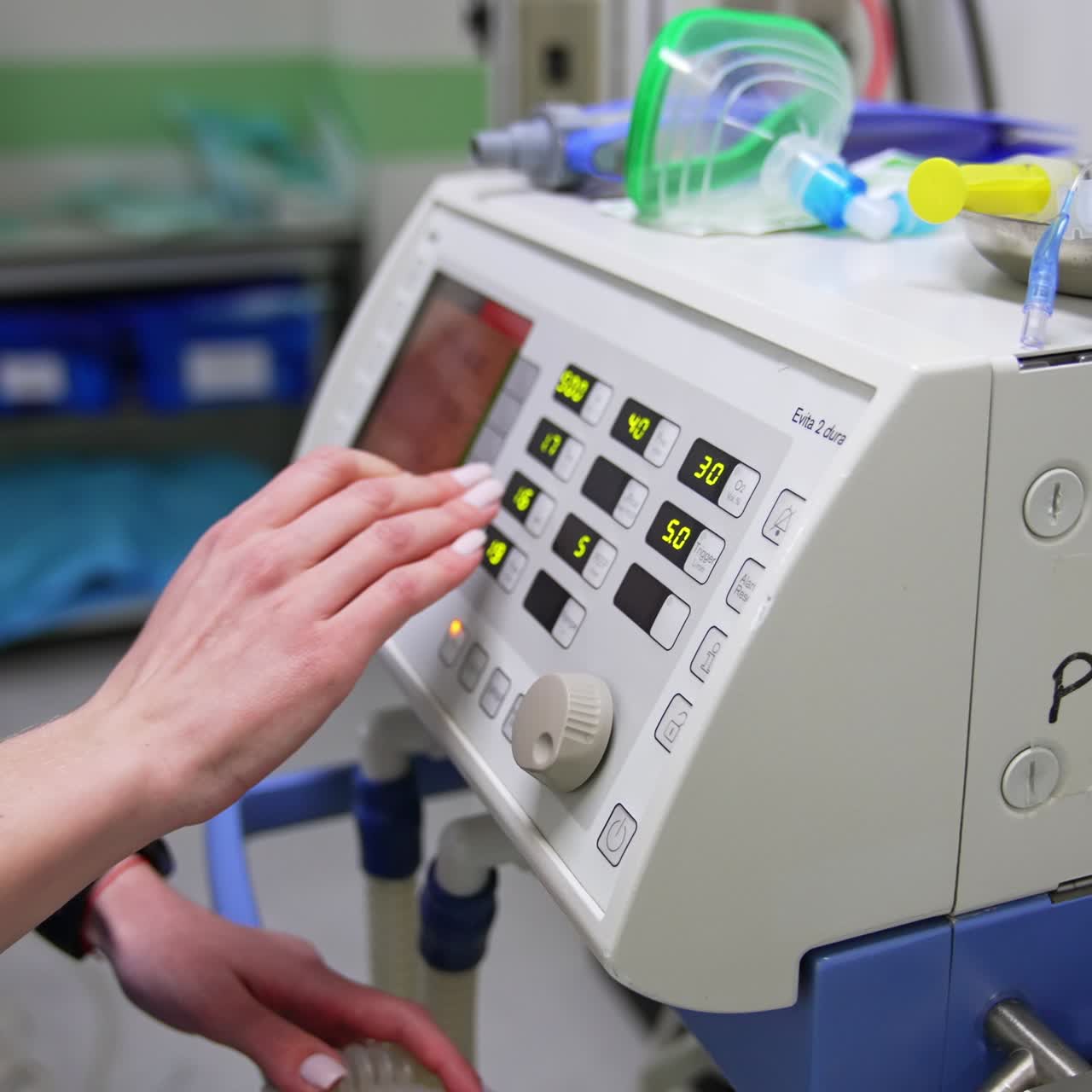 Female hand pressing the buttons on the equipment in surgery room. Close up. Modern operational theatre backdrop
