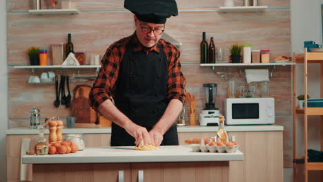 Old-man-with-kitchen-apron-cooking-bread