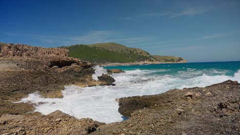 splashing waves at spanish island coast line with clear water in slowmotion