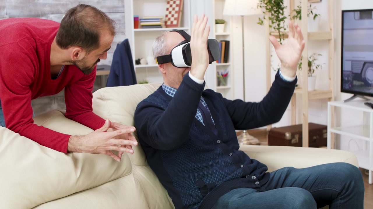 Giovane uomo che aiuta un uomo anziano a usare un visore per la realtà virtuale a casa
