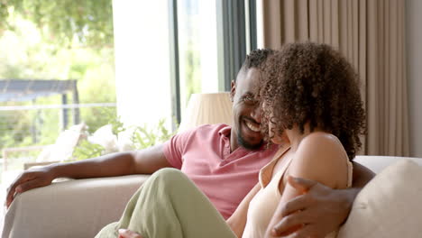 smiling couple sitting on couch, enjoying quality time together at home
