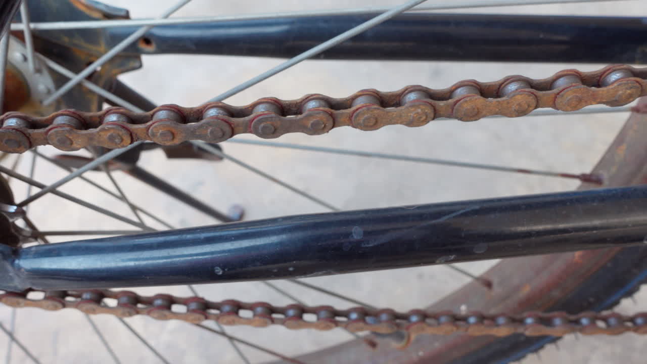 video en primer plano de 4k de una cadena y engranajes de bicicleta envejecidos y oxidados, con movimiento de deslizamiento de dolly en una exploración detallada del desgaste y la textura