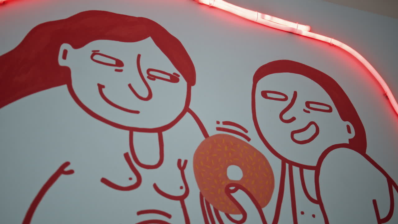 una pareja sonriente compartiendo una rosquilla