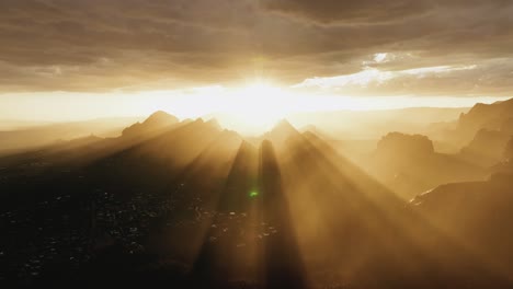 sunlight bursting through clouds during sunrise over sedona, arizona, usa