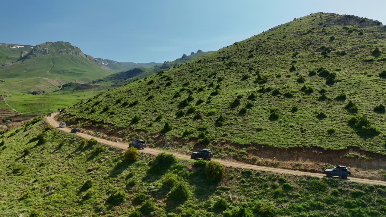 Off-road vehicles drive through scenic mountain landscape, adventure concept