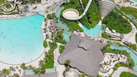 people enjoying leisure time in aqua park, swimming, sliding down water slide aerial orbit
