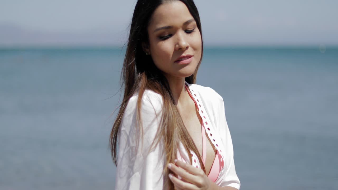 해변에서 포즈를 취하는 아름다운 소녀