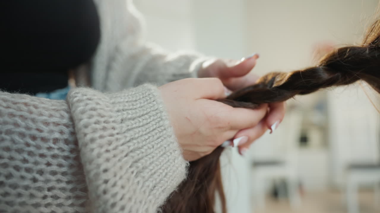 Caucasian Student Practicing Braid Technique In Studio Hands Work Through Long Hair With Steady Fingers, Knit Sleeve And Denim, Educational Setting, Calm Concentration, HandsOn Learning Environment