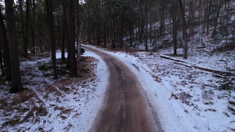 Smooth-drone-footage-of-a-beautiful-road-through-a-snowy-winter-forest-in-the-Appalachian-mountains-during-winter-in-New-York's-Hudson-Valley-in-the-Catskill-Mountains-sub-range