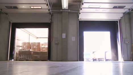 inside a brightly lit warehouse, sunlight streams through open dock doors revealing stacked cargo boxes