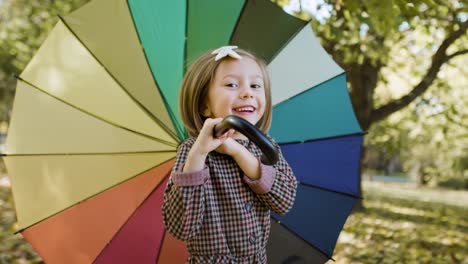 handheld view of joyful girl looking for shelter with umbrella