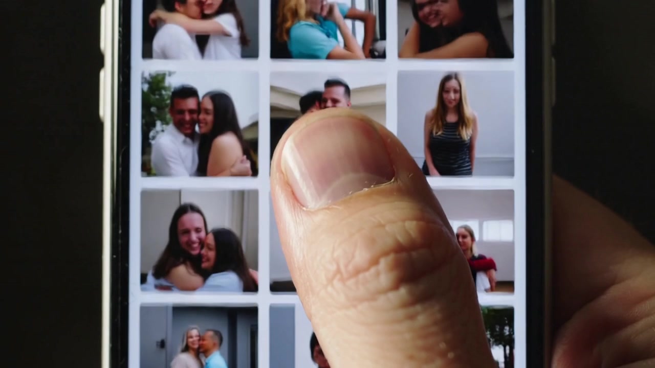 Polegar direito de adulto tocando e começando a rolar no telefone em casa, encontrando um retrato em uma galeria casual.