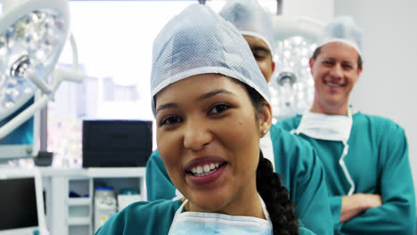 Portrait-of-surgeons-and-nurse-standing-with-arms-crossed-in-operation-room