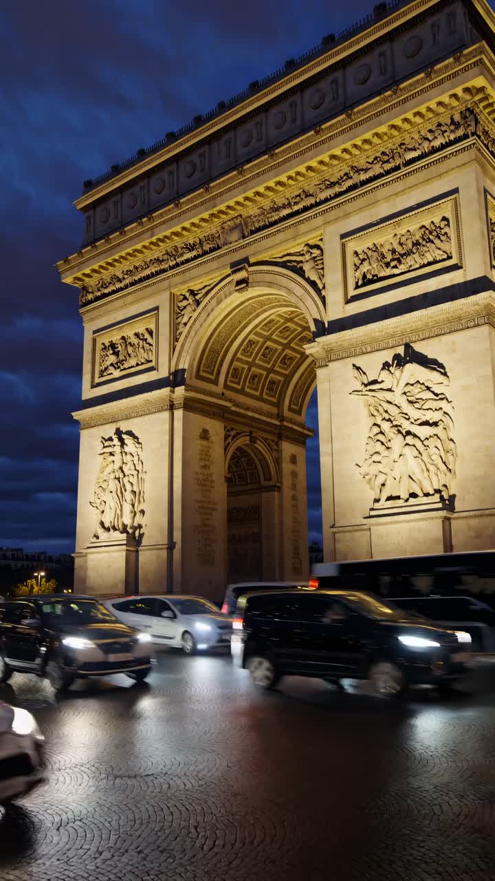 Nighttime video of the Arc de Triomphe with a low-angle view, capturing the illuminated monument