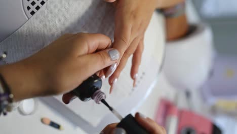 nail artist applying polish in salon