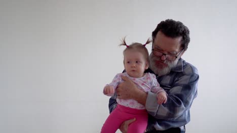 abuelo con barba y gafas jugando con una pequeña nieta adorable 2